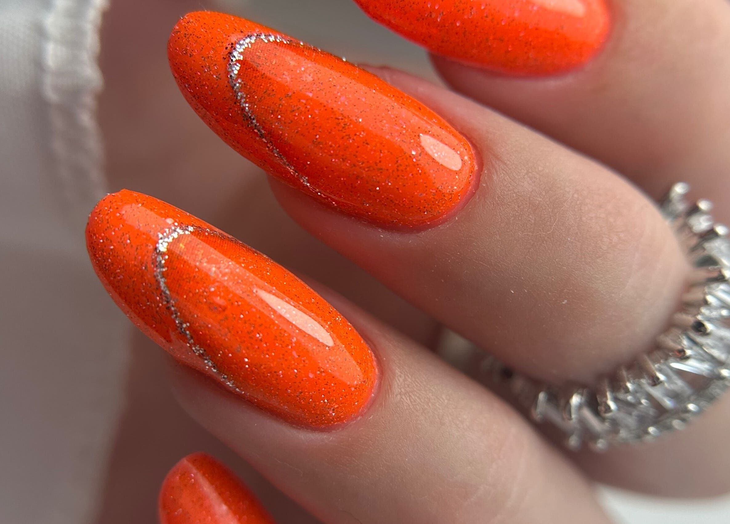 Stylish orange glitter nails at Daniela Siantova Nail Courses in Hull, England, GB, showcasing expert artistry.