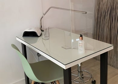 Elegant nail station at Kate Brooks ~ Nail Artist, Llandudno, Wales, GB, featuring a sleek glass table and modern chair.