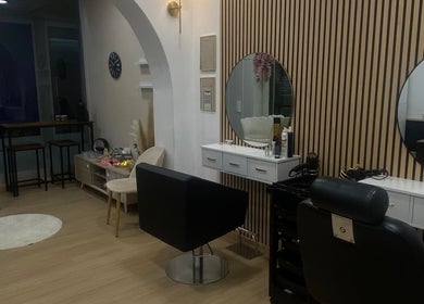 Interior elegante do Aura Salon em Aveiro, Aveiro, PT com espelhos modernos e poltronas confortáveis.