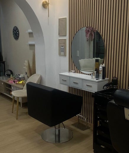 Interior elegante do Aura Salon em Aveiro, Aveiro, PT com espelhos modernos e poltronas confortáveis.