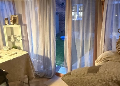 Relaxing treatment room at Beautyby L Cheshire, Northwich, England, GB with soft curtains and cozy decor.