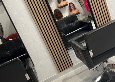 Interior moderno do Marina Lima cabeleireira afro em Lisboa, Lisboa, PT, com cadeiras pretas elegantes.