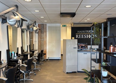Interieur van HAIRSTUDIO REESHOF in Tilburg, Noord-Brabant, NL met modern meubilair en elegante verlichting.