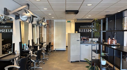 Interieur van HAIRSTUDIO REESHOF in Tilburg, Noord-Brabant, NL met modern meubilair en elegante verlichting.