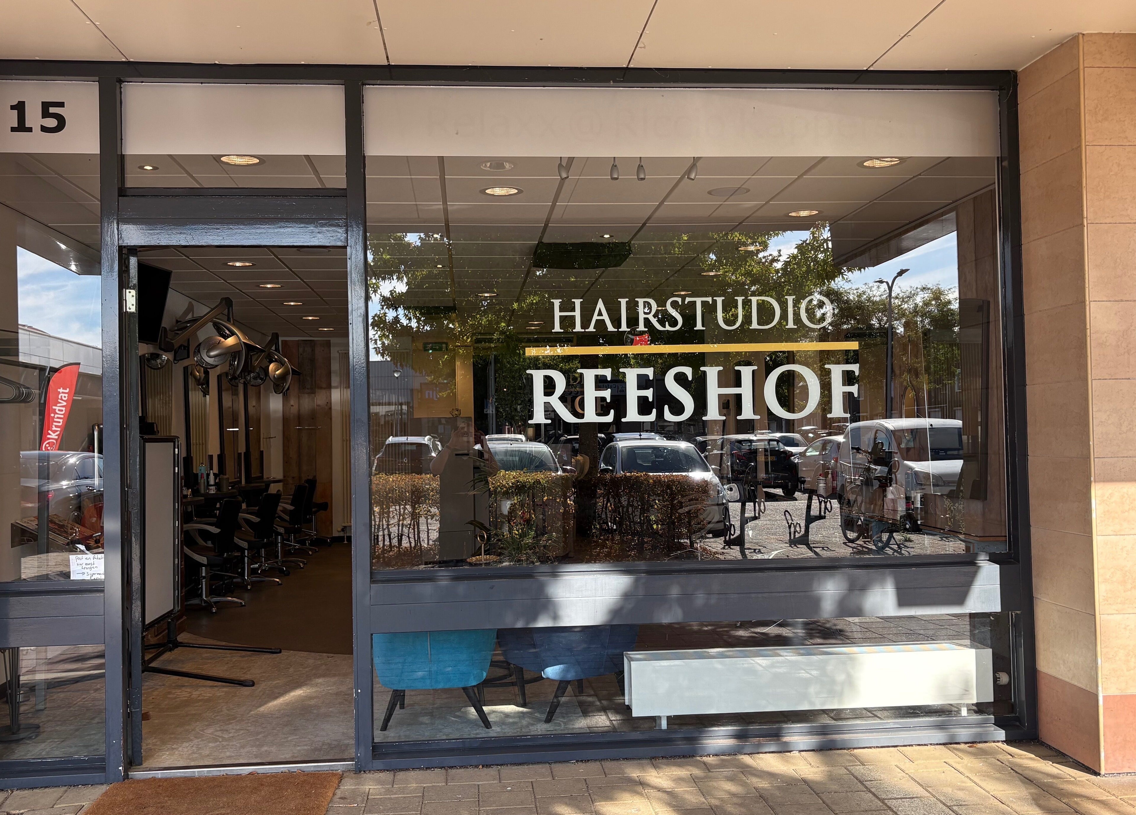 Ingang van HAIRSTUDIO REESHOF in Tilburg, Noord-brabant, NL met stijlvolle glazen gevel.