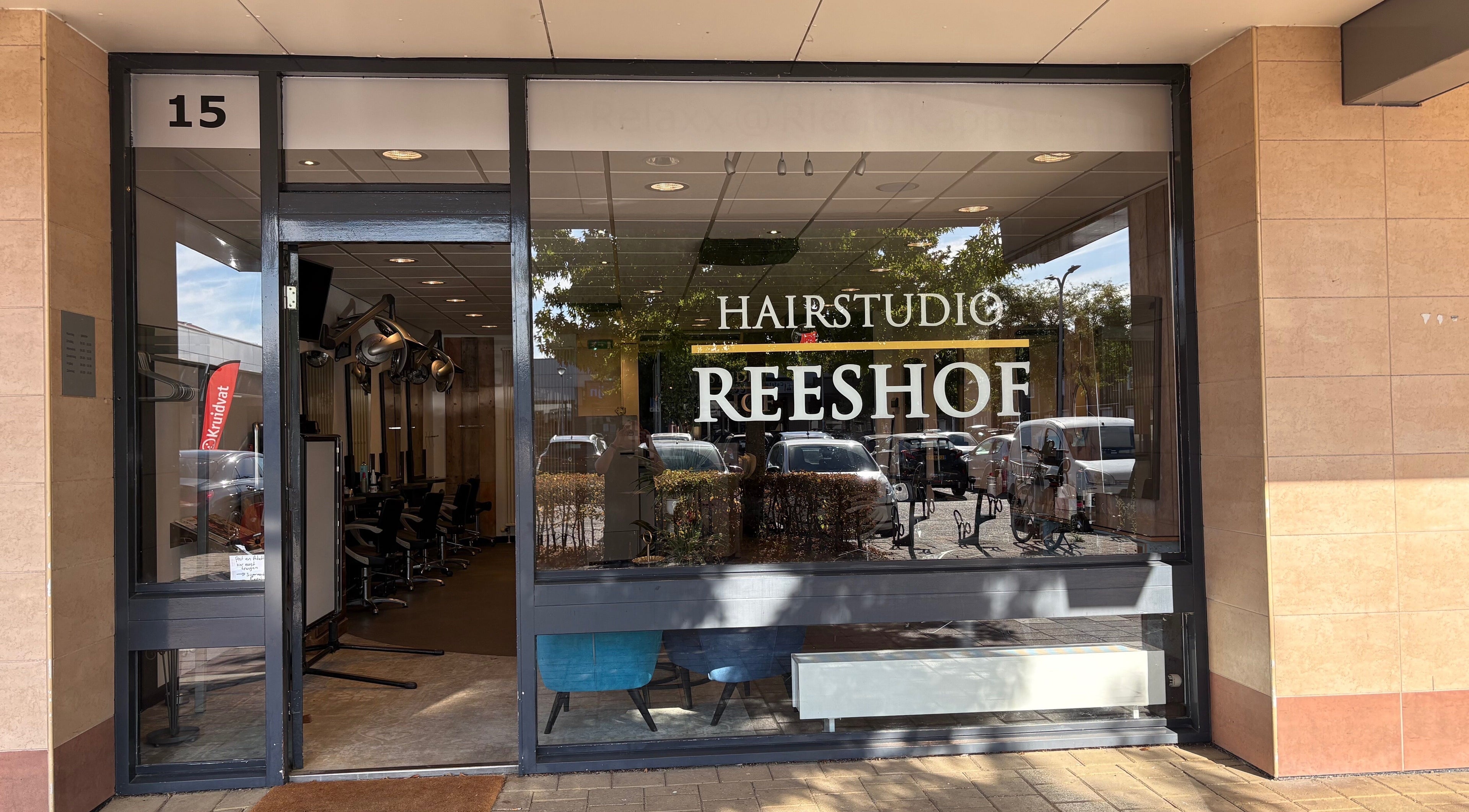 Ingang van HAIRSTUDIO REESHOF in Tilburg, Noord-brabant, NL met stijlvolle glazen gevel.