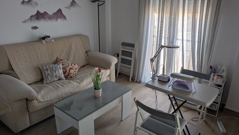 Zona acogedora en Bren Estetica, Brenes, Andalucía, ES, con sofá, mesa y herramientas de belleza.