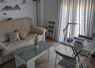 Zona acogedora en Bren Estetica, Brenes, Andalucía, ES, con sofá, mesa y herramientas de belleza.
