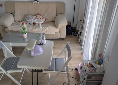 Interior acogedor en Bren Estetica, Brenes, Andalucía, ES, con mesa de tratamiento y sofá beige.
