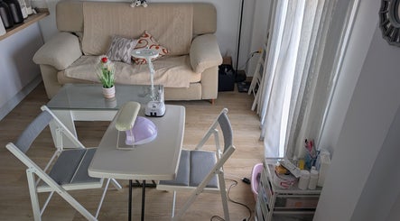 Interior acogedor en Bren Estetica, Brenes, Andalucía, ES, con mesa de tratamiento y sofá beige.