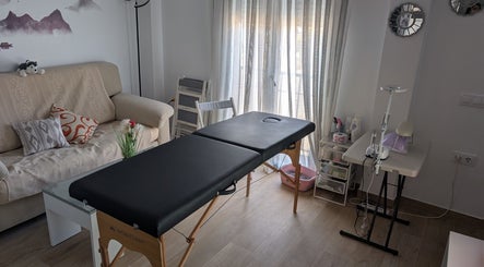 Sala de tratamiento en Bren Estetica, Brenes, Andalucía, ES, con camilla y sofá acogedor.