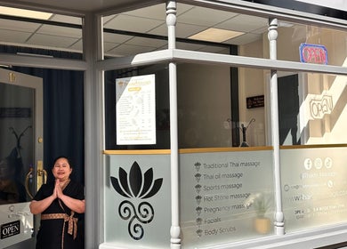 Entrance of Thaidy Massage in Newport, Wales, GB with a welcoming staff member in traditional attire.
