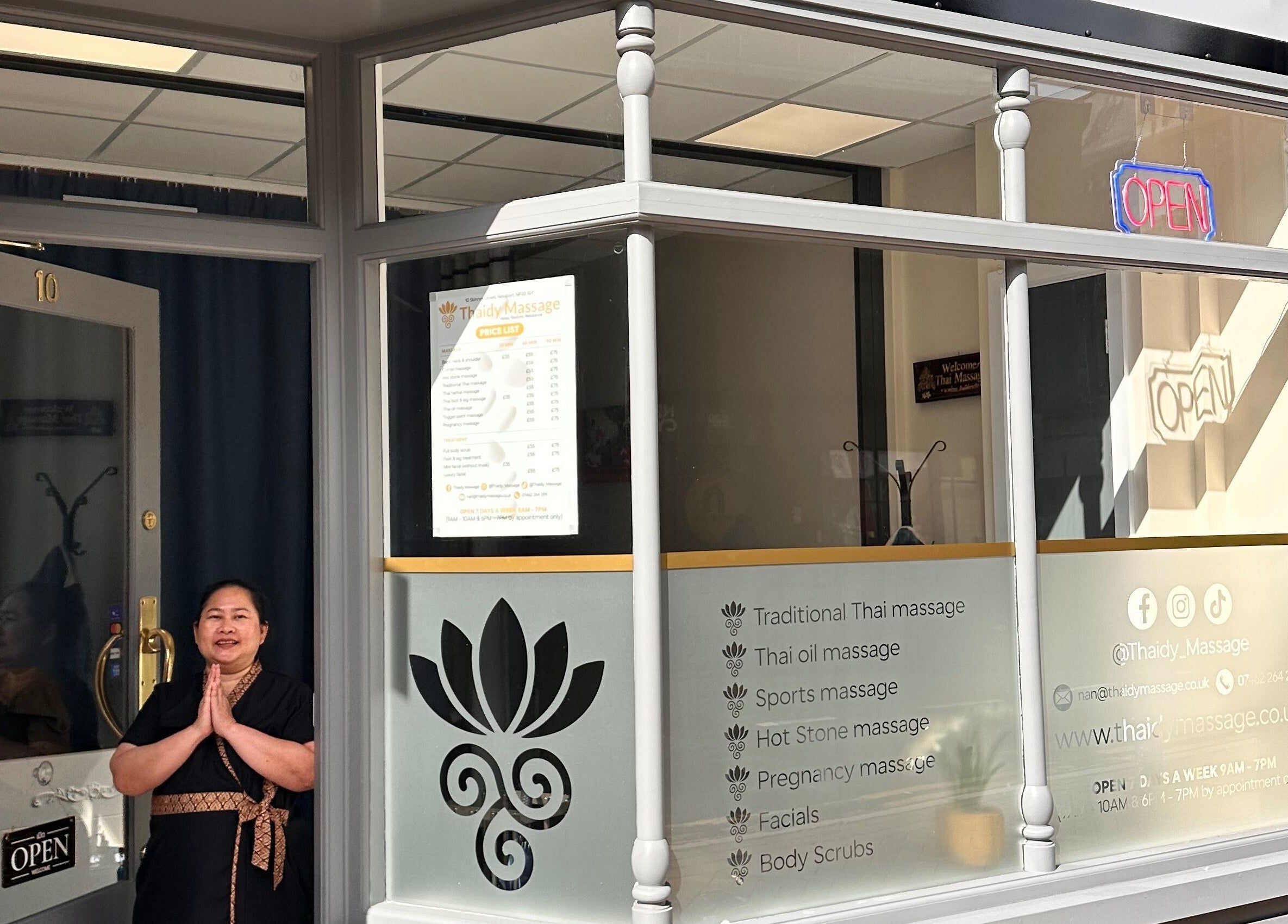 Entrance of Thaidy Massage in Newport, Wales, GB with a welcoming staff member in traditional attire.
