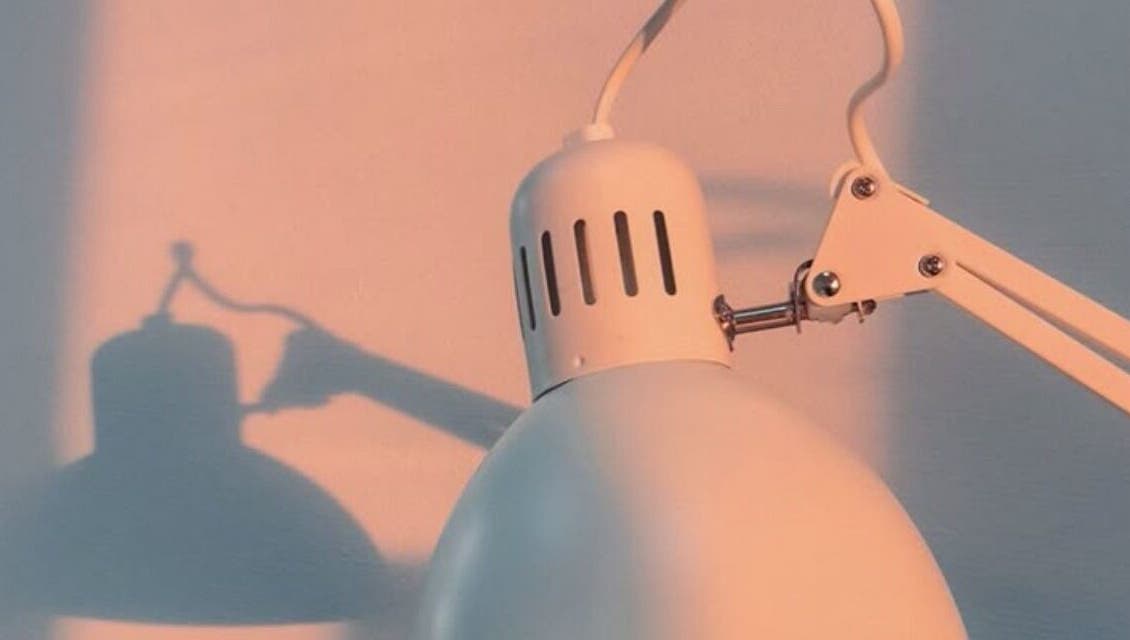 Modern lamp casting artistic shadows at Classic Touch, Noord, AW enhancing serene beauty ambiance.