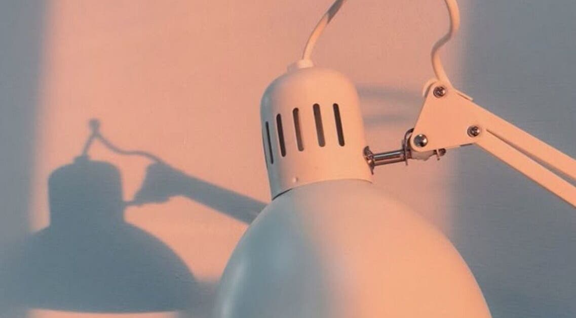 Modern lamp casting artistic shadows at Classic Touch, Noord, AW enhancing serene beauty ambiance.