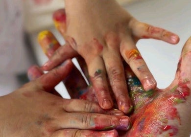 Mãos coloridas de criança em atividade sensorial no BM Terapias, Freamunde, Porto, PT.