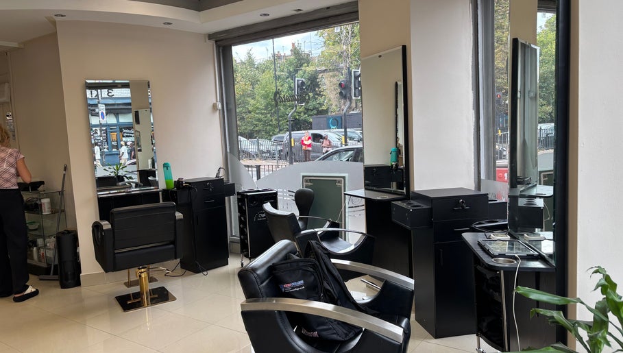 Chic interior of Glamora Hair in London, England, GB, featuring styling stations and large windows.