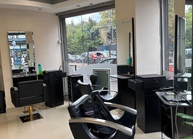 Chic interior of Glamora Hair in London, England, GB, featuring styling stations and large windows.