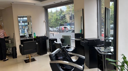 Chic interior of Glamora Hair in London, England, GB, featuring styling stations and large windows.