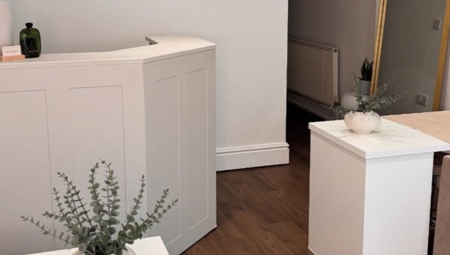 Elegant reception area at Halo Skin Lab in Worsley, England, GB with modern decor and plant accents.