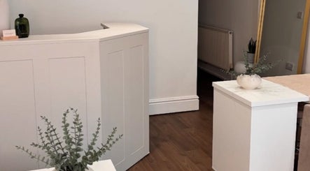 Elegant reception area at Halo Skin Lab in Worsley, England, GB with modern decor and plant accents.