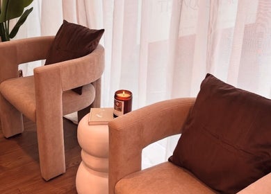 Cozy seating area at Halo Skin Lab in Worsley, England, GB with plush chairs and a lit candle.