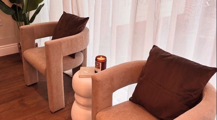 Cozy seating area at Halo Skin Lab in Worsley, England, GB with plush chairs and a lit candle.