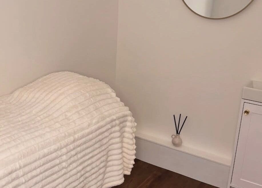 Cozy treatment room at Halo Skin Lab, Worsley, England, GB featuring a plush bed and calming decor.