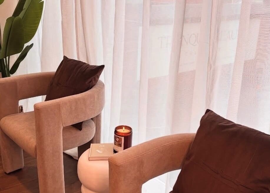 Relaxing seating area at Halo Skin Lab, Worsley, England, GB, featuring stylish chairs and a candle.