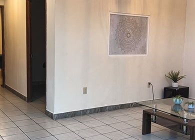 Rincón acogedor en Salud Pro, Irapuato, Guanajuato, MX con mesa de vidrio y plantas decorativas.