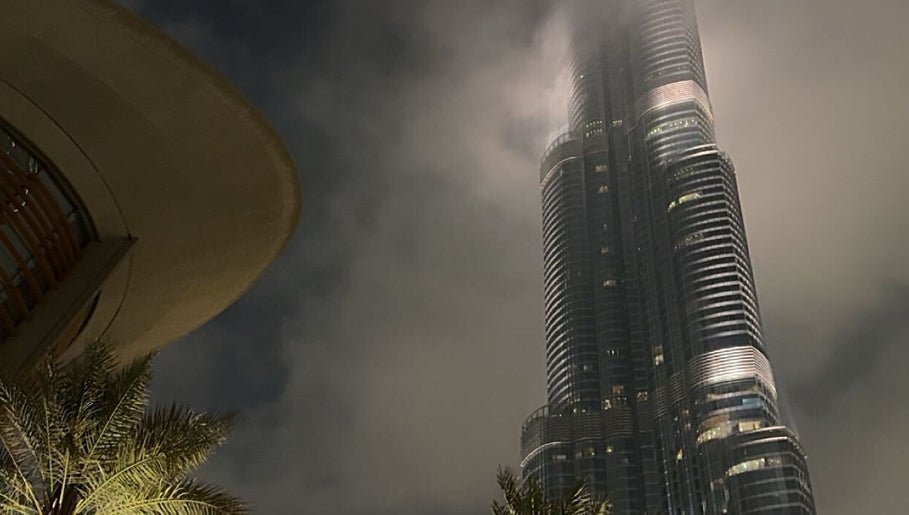 Towering skyscraper near J-blendz salon in Casablanca, Casablanca-Settat, MA under a misty night sky.