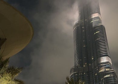 Towering skyscraper near J-blendz salon in Casablanca, Casablanca-Settat, MA under a misty night sky.