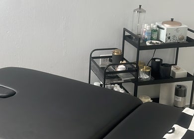 Treatment room at BROWOLOGY, Carolina, San Juan, PR showcasing a massage table and skincare products.