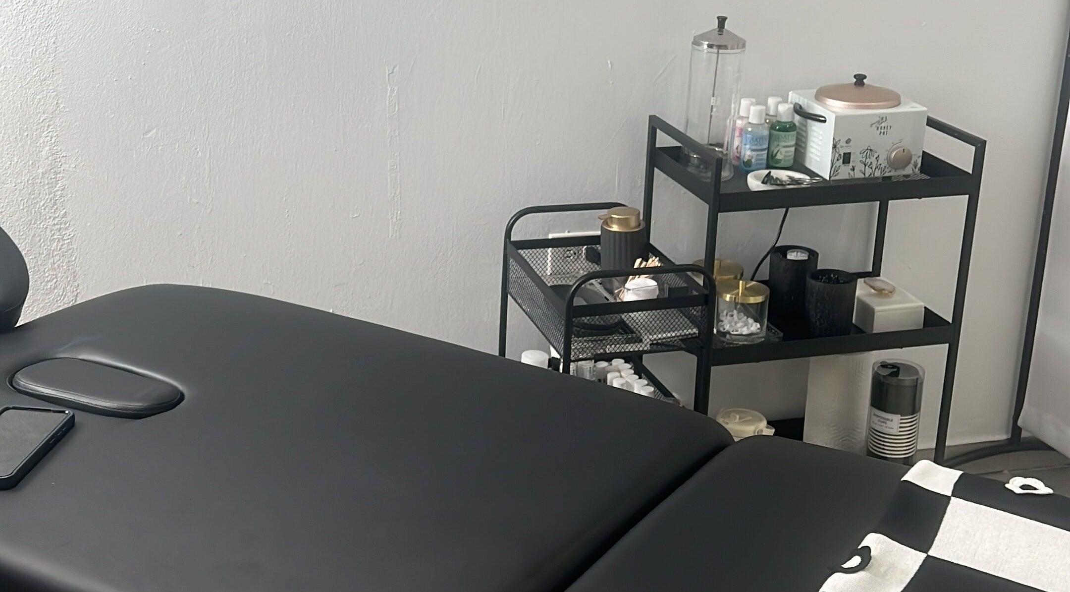 Treatment room at BROWOLOGY, Carolina, San Juan, PR showcasing a massage table and skincare products.