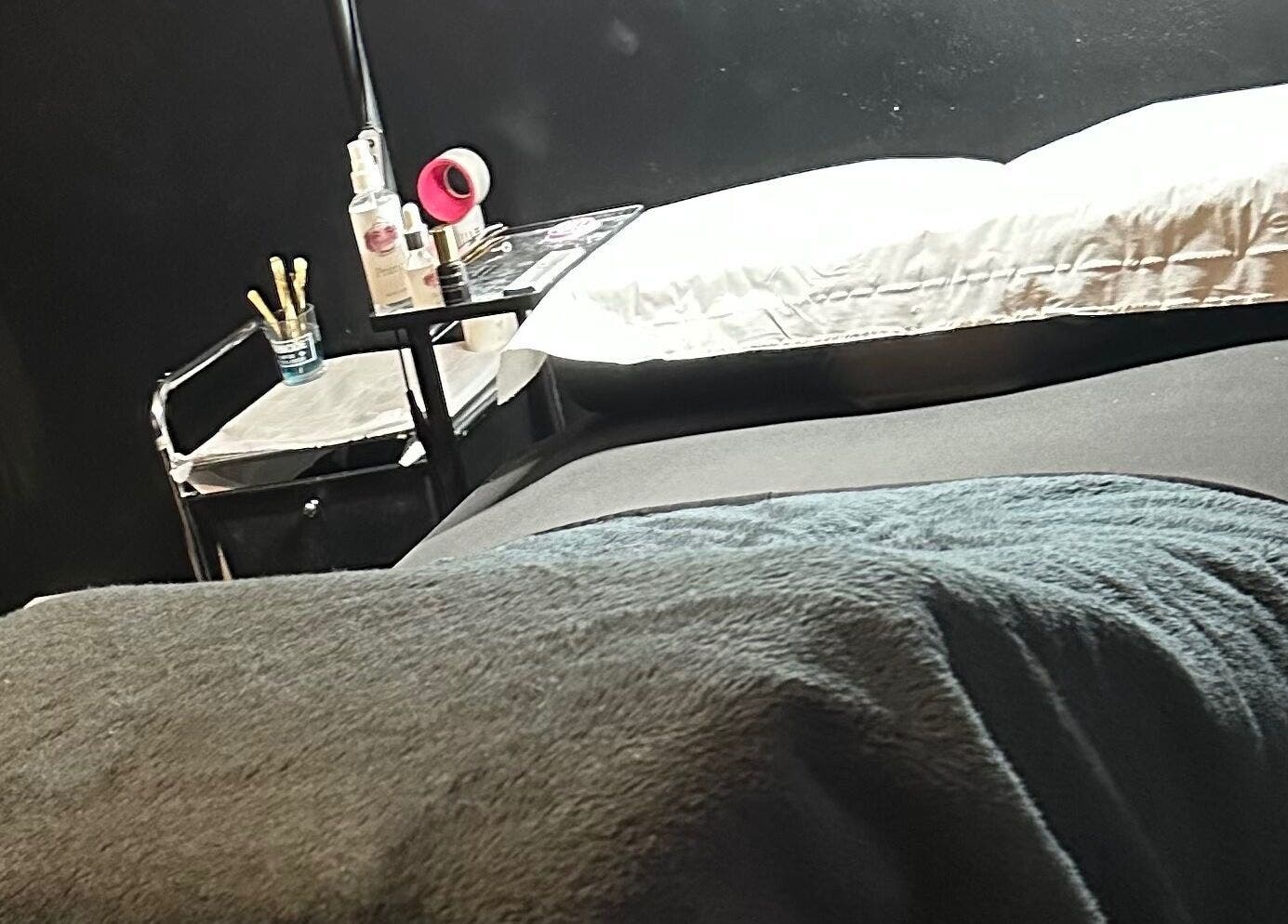 Cozy treatment room at Cut Loose in Wigan, England, GB, with a comfortable massage table and beauty products.