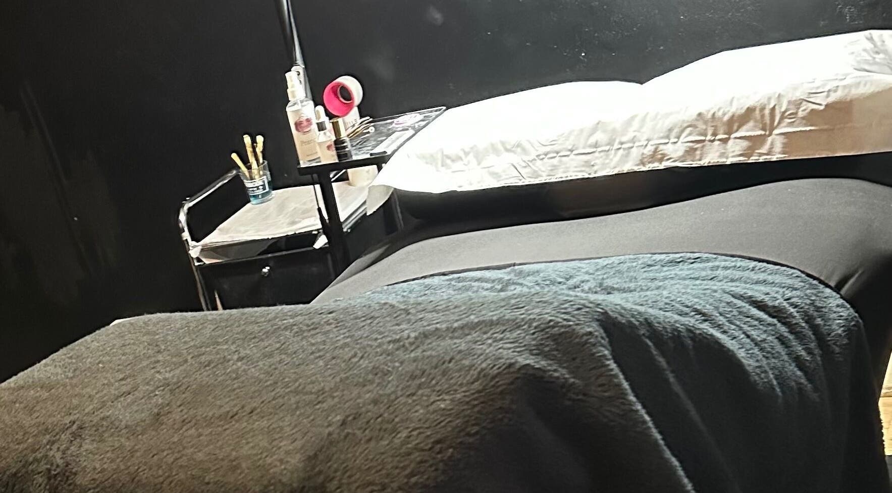 Cozy treatment room at Cut Loose in Wigan, England, GB, with a comfortable massage table and beauty products.