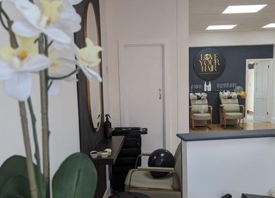 Love Your Hair salon interior in Totton, England, GB featuring chic seating and floral decor.
