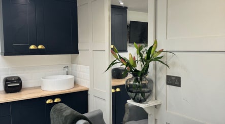 Elegant interior of The Garden Salon in Swindon, England, GB with a modern sink and decorative flowers.