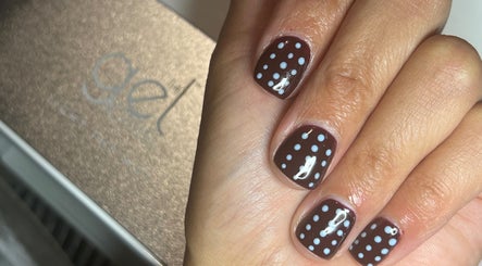 Polka dot nail art from NailsbySa in Cardiff, Wales, GB showcasing trendy brown and white design.