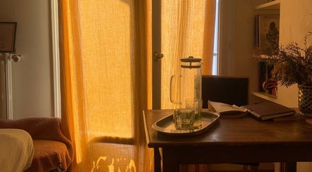 Lumière dorée filtrée par des rideaux au lieu Prana Paris Massage et naturopathie selon l’Ayurvéda, Paris, Île-de-France, FR.