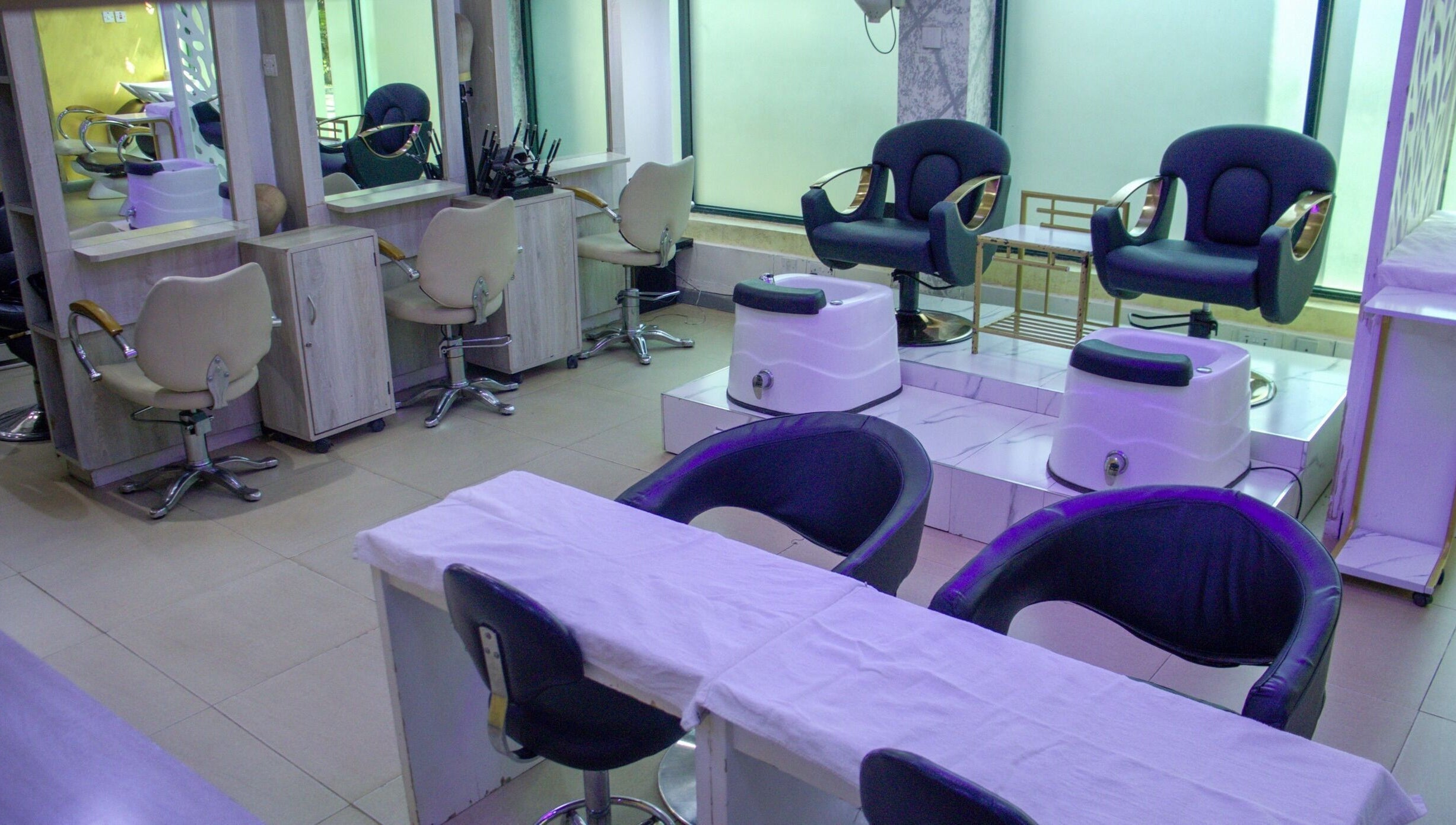 Modern salon interior at Strands On Fleek Hair & Nail Bar, Nairobi, Nairobi, KE with black and beige chairs.