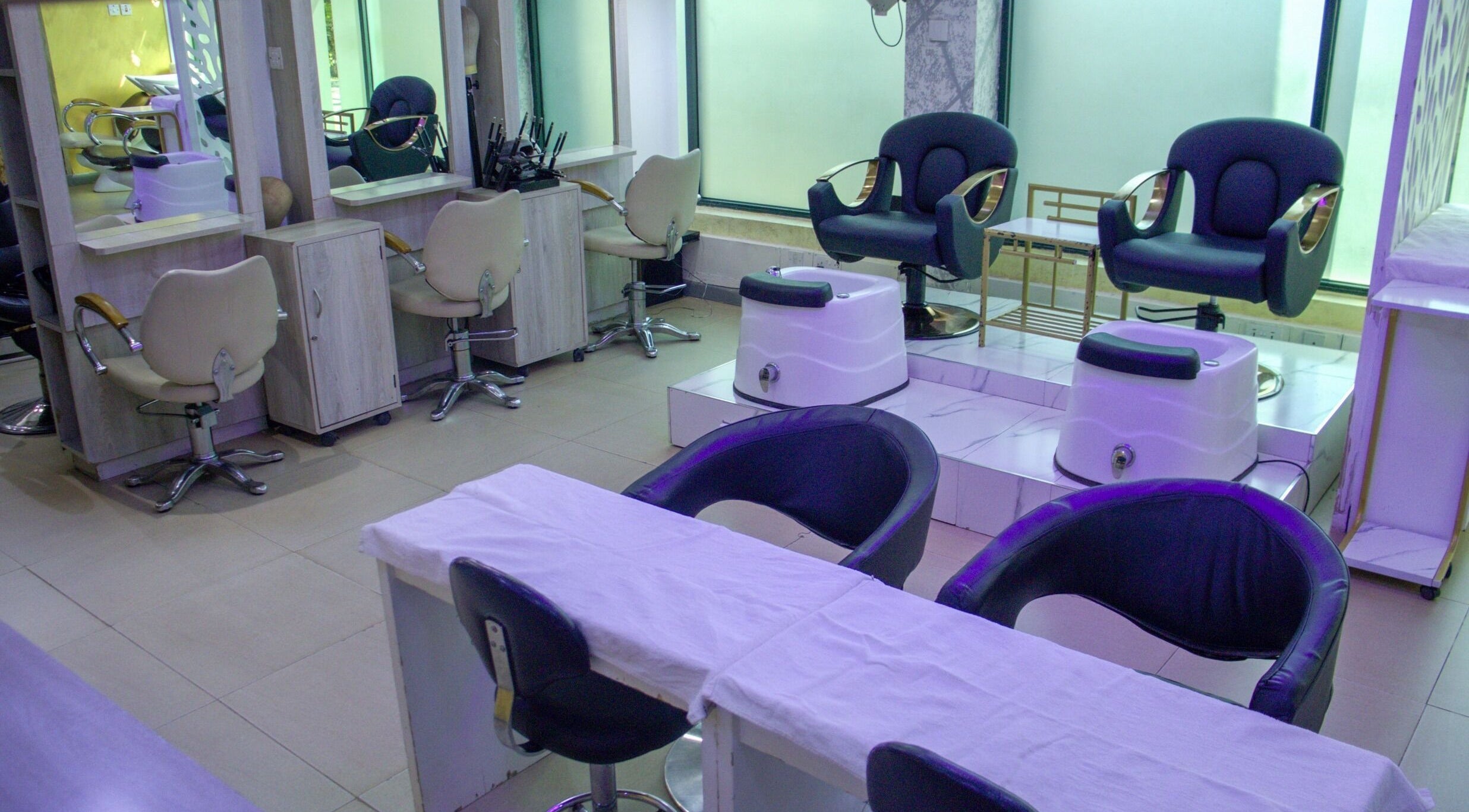 Modern salon interior at Strands On Fleek Hair & Nail Bar, Nairobi, Nairobi, KE with black and beige chairs.