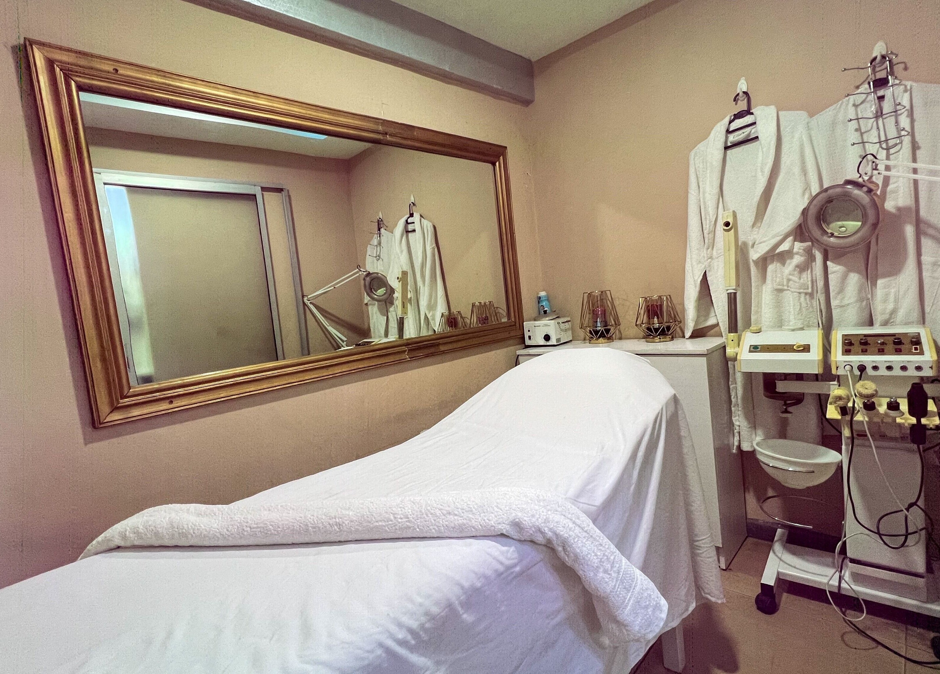Relaxing spa room at Strands On Fleek Hair & Nail Bar, Nairobi, Nairobi, KE showcasing a massage bed and equipment.