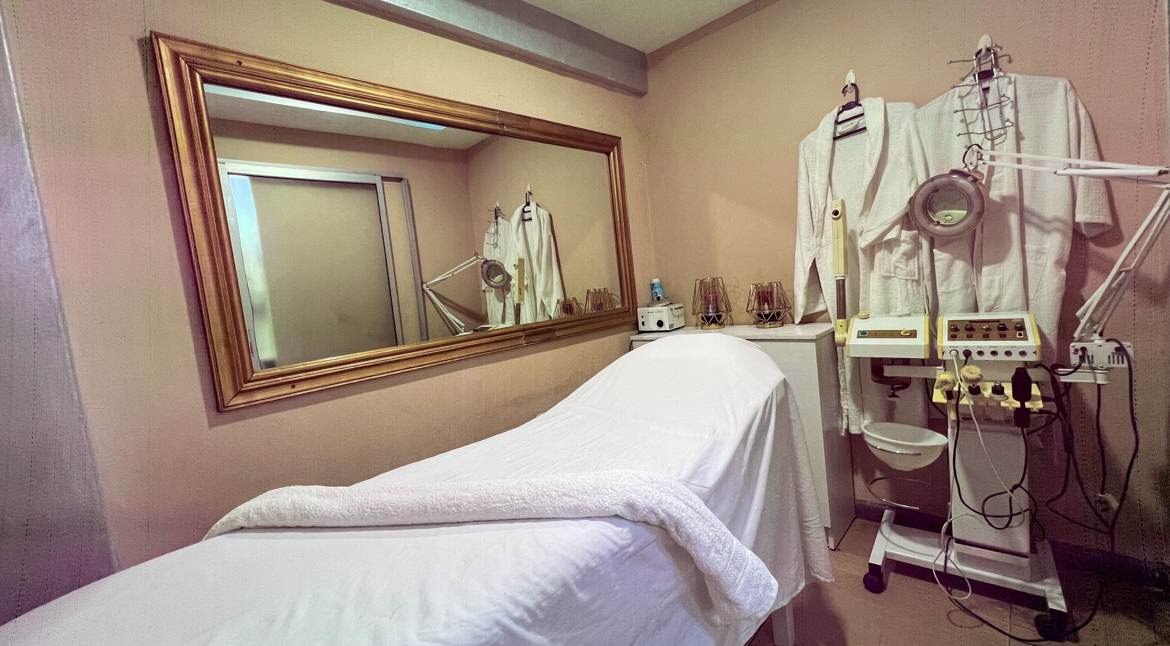 Relaxing spa room at Strands On Fleek Hair & Nail Bar, Nairobi, Nairobi, KE showcasing a massage bed and equipment.