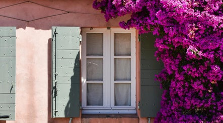 Fenêtre entourée de fleurs vibrantes à Entre Hyères et Deux Mains, Hyères, Provence-alpes-côte D'azur, FR.