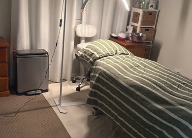Cozy treatment room at Elegance by Bronte, Uralla, New South Wales, AU with a striped bed and soft lighting.