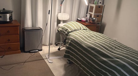 Cozy treatment room at Elegance by Bronte, Uralla, New South Wales, AU with a striped bed and soft lighting.