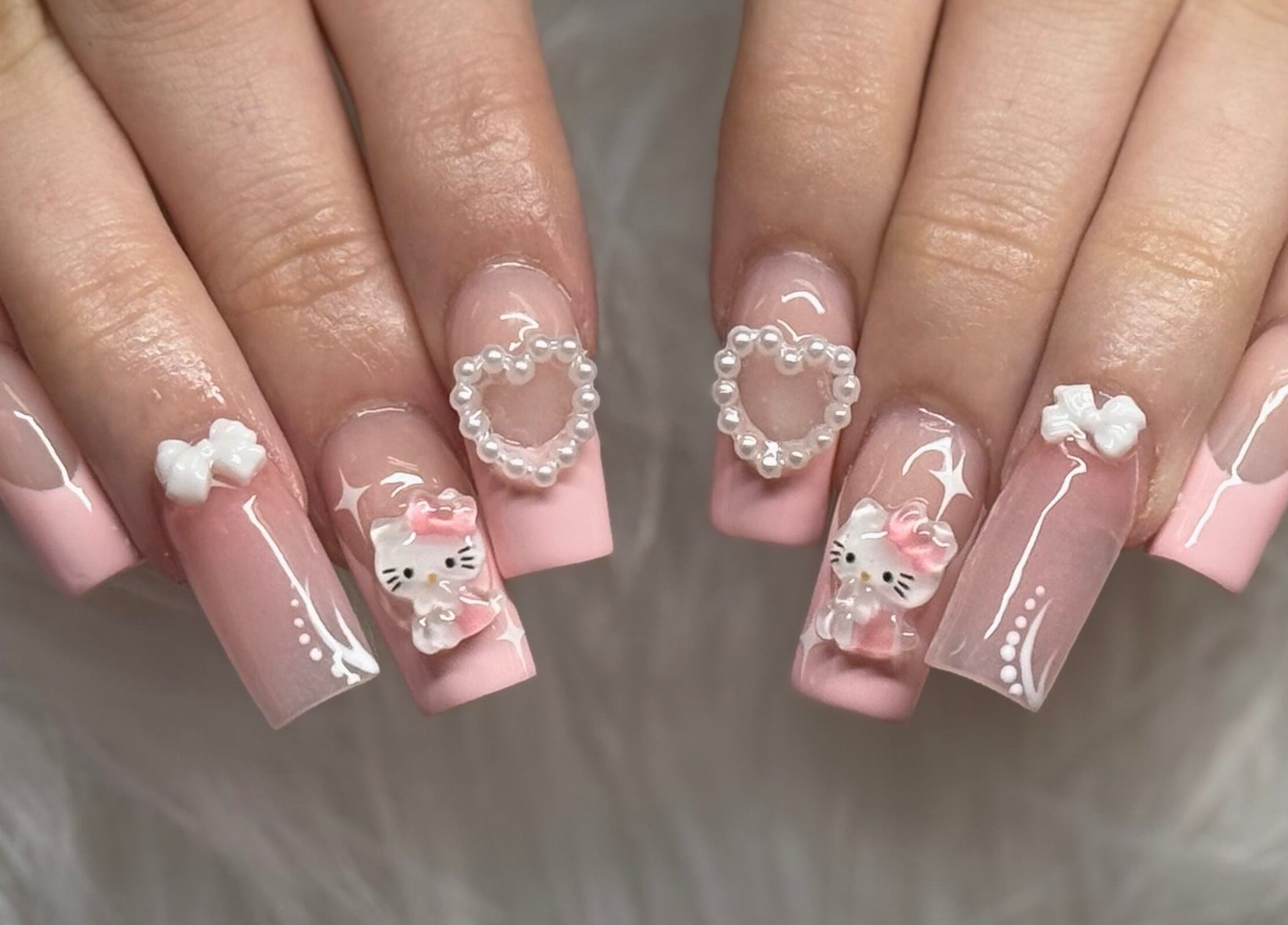 Elegant pink nail design with cute charms at Klawedbykat, Swaffham, England, GB.
