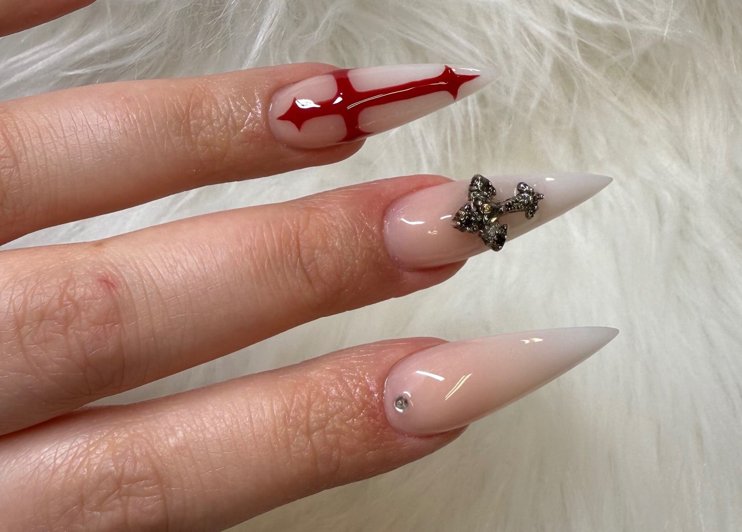 Intricate nail art with red design and rhinestones at Klawedbykat, Swaffham, England, GB.