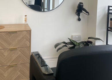 Modern KOZY salon interior in Hindley, England, GB showcasing sleek design with a styling chair and products.